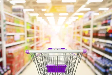 supermarket-aisle-product-shelves-interior-blur-background-with-empty-shopping-cart_293060-4045
